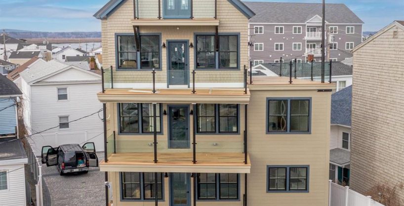 a two story house with a lot of windows and balconies.