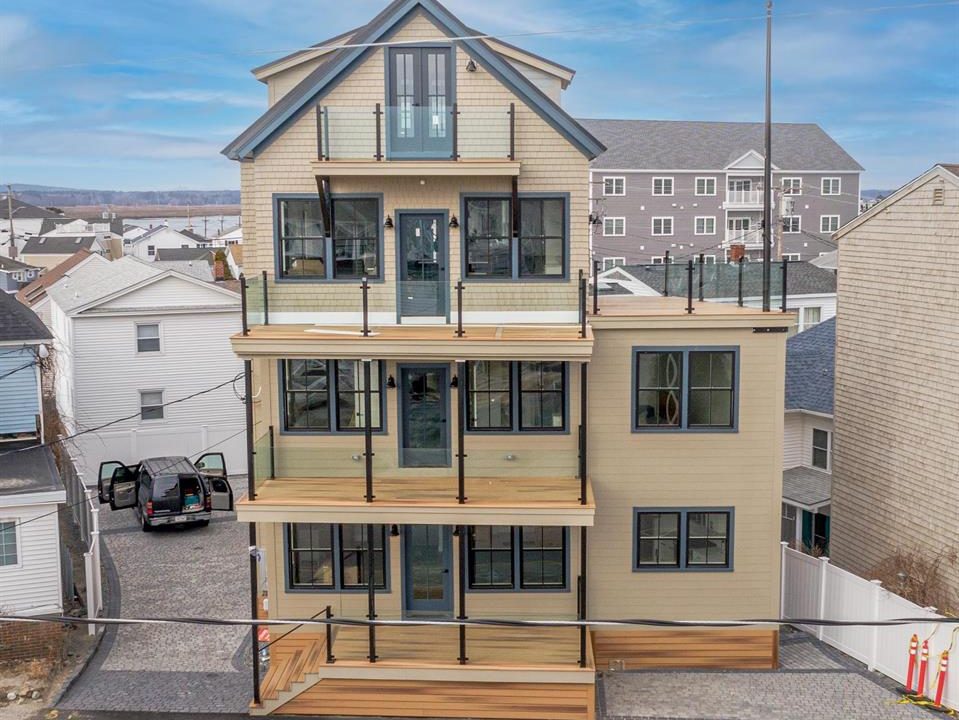 a two story house with a lot of windows and balconies.