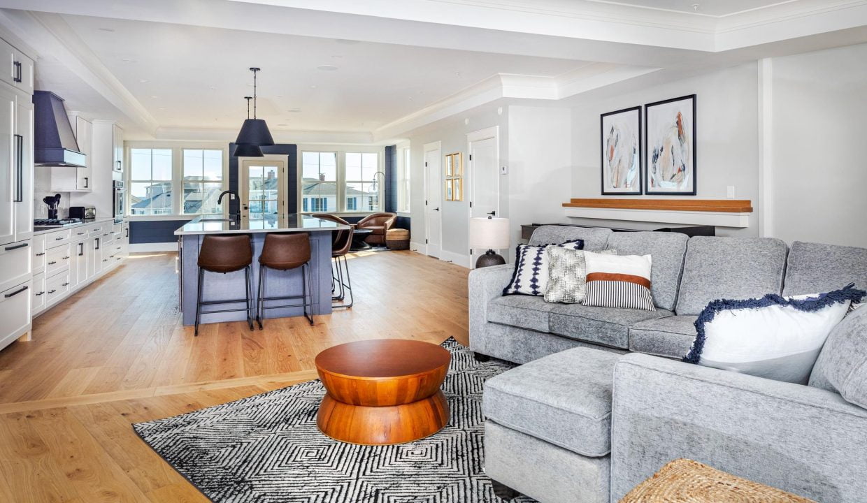 a living room filled with furniture and a kitchen.