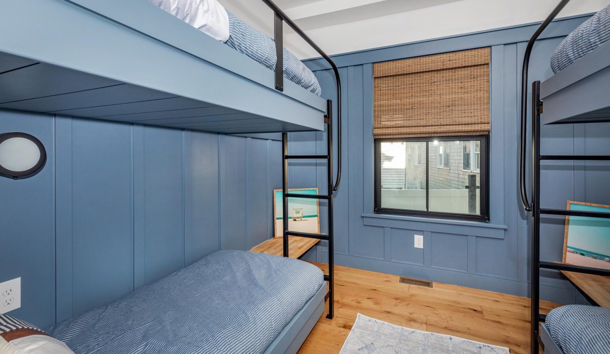 a bedroom with bunk beds and blue walls.