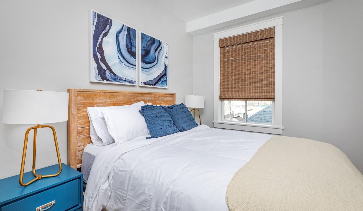 a bedroom with a white bed and blue nightstands.