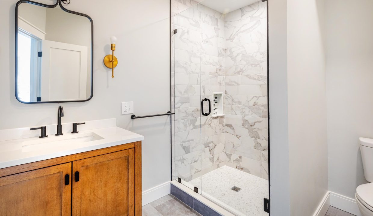 a bathroom with a walk in shower next to a sink.