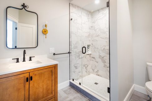 a bathroom with a walk in shower next to a sink.