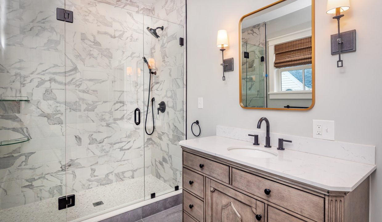 a bathroom with a walk in shower next to a sink.