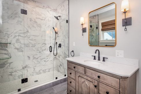 a bathroom with a walk in shower next to a sink.