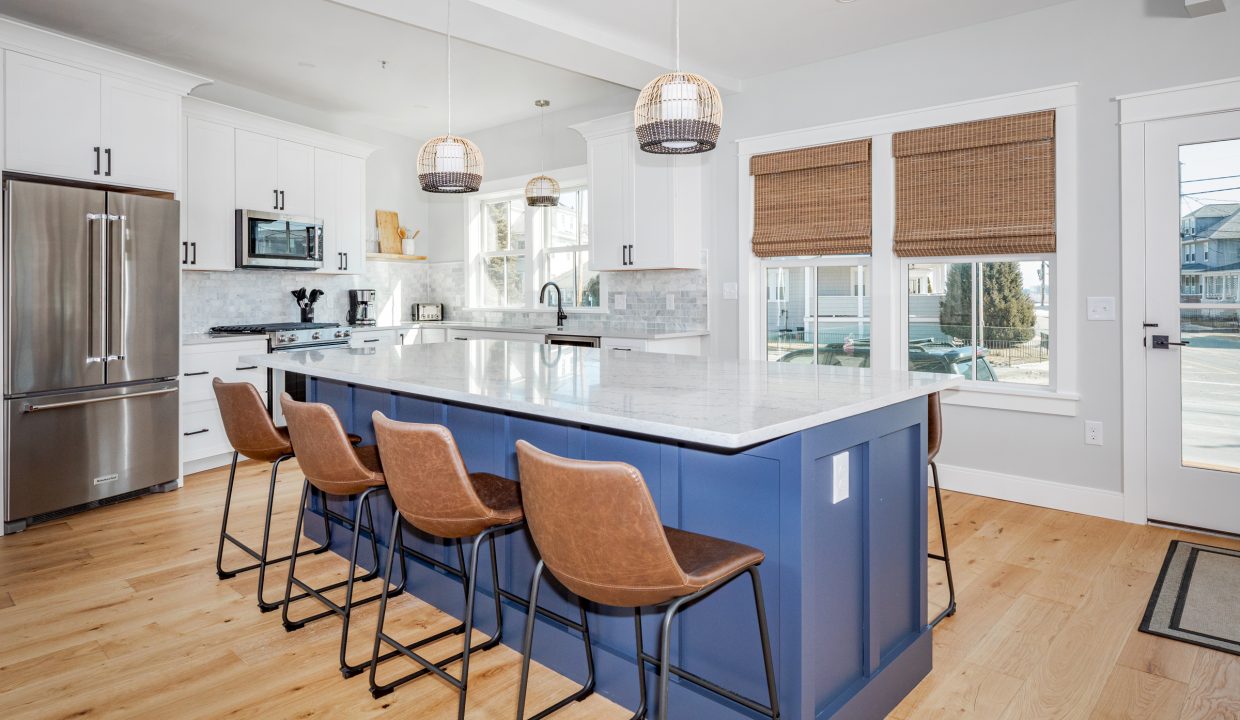 a kitchen with a center island with four bar stools.