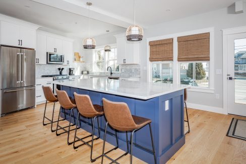 a kitchen with a center island with four bar stools.