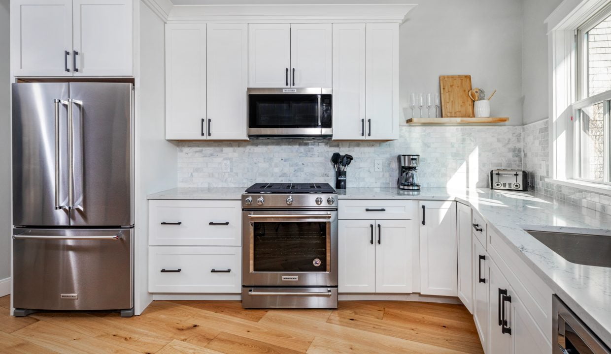 a kitchen with white cabinets and stainless steel appliances.