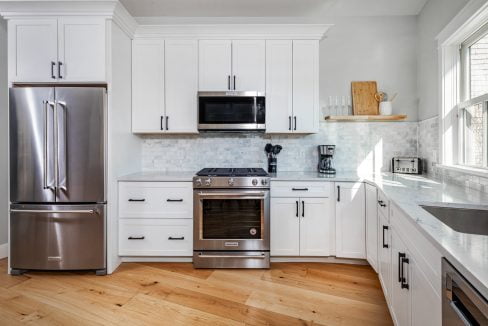 a kitchen with white cabinets and stainless steel appliances.
