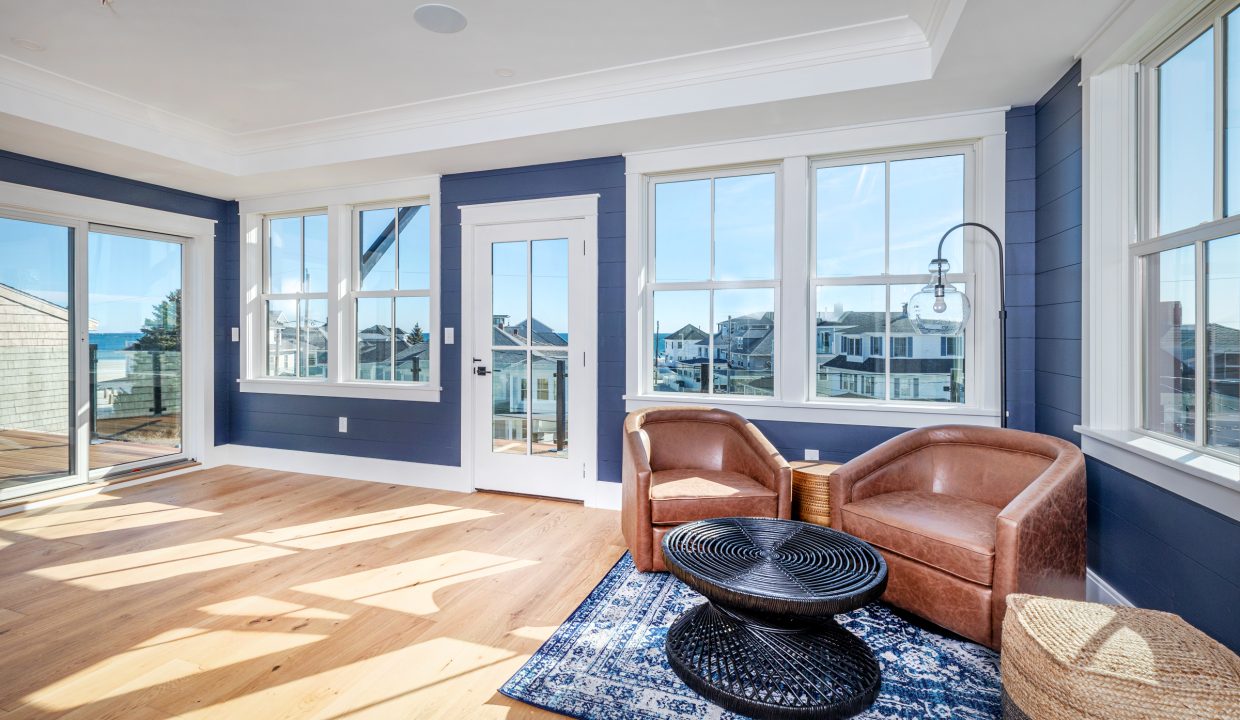 a living room filled with furniture and windows.