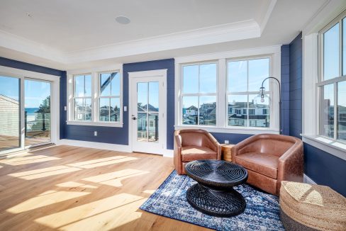 a living room filled with furniture and windows.