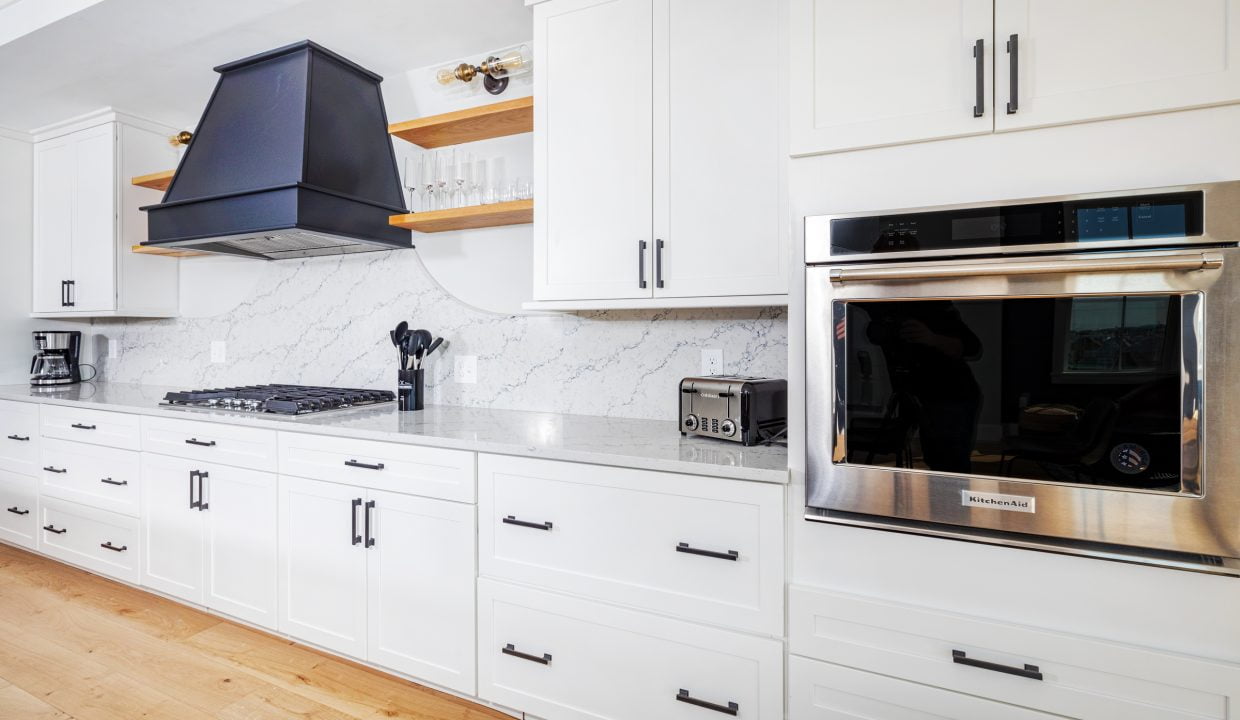 a kitchen with white cabinets and a stainless steel oven.