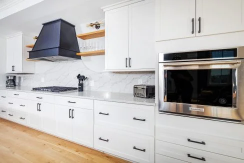 a kitchen with white cabinets and a stainless steel oven.