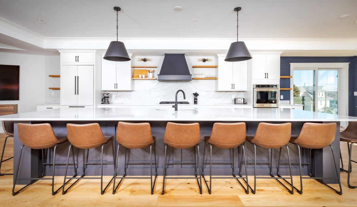 a large kitchen with a center island and bar stools.