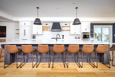 a large kitchen with a center island and bar stools.
