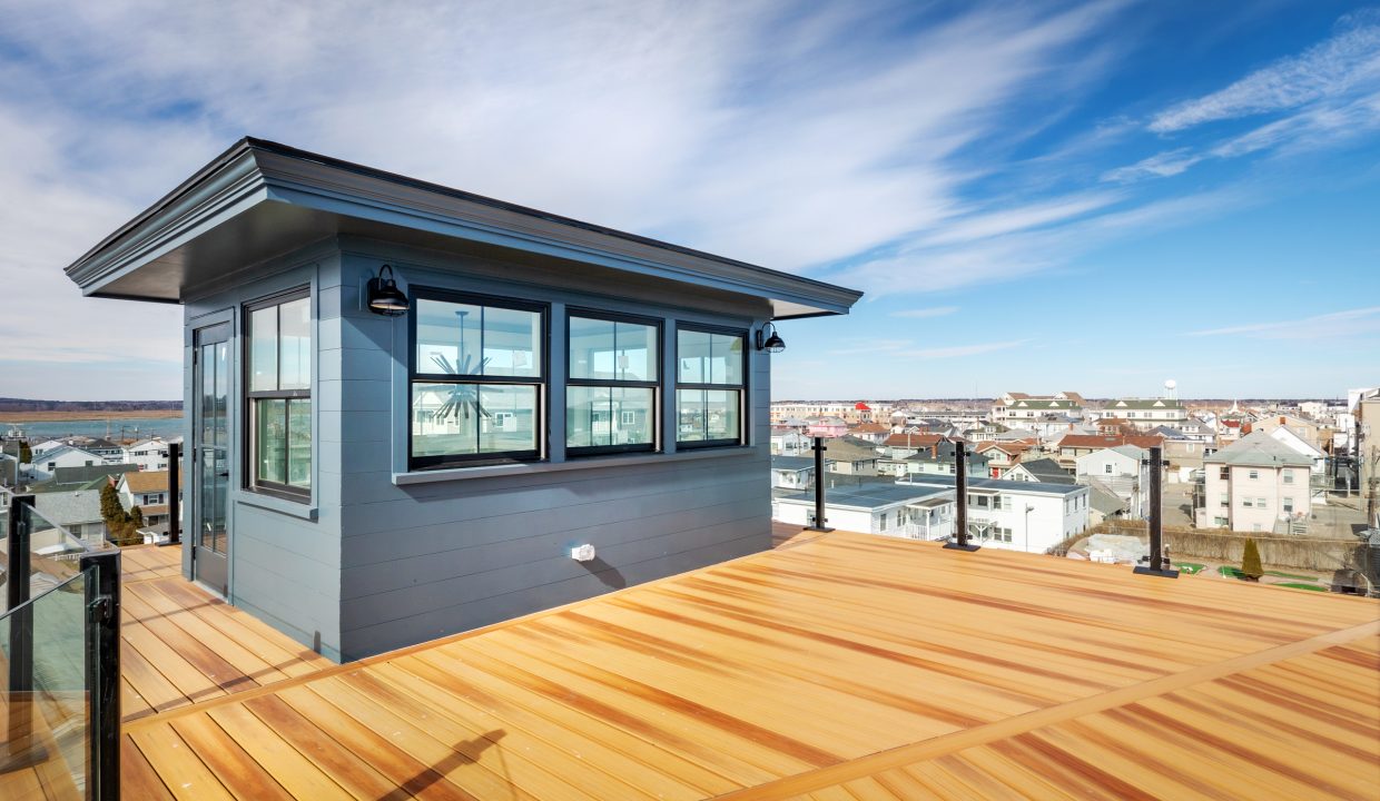 a small blue house on a wooden deck.