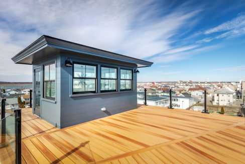 a small blue house on a wooden deck.