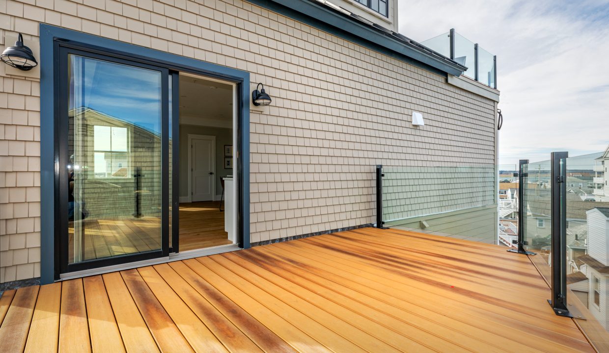 a wooden deck with a sliding glass door.