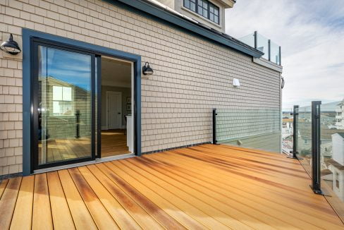 a wooden deck with a sliding glass door.