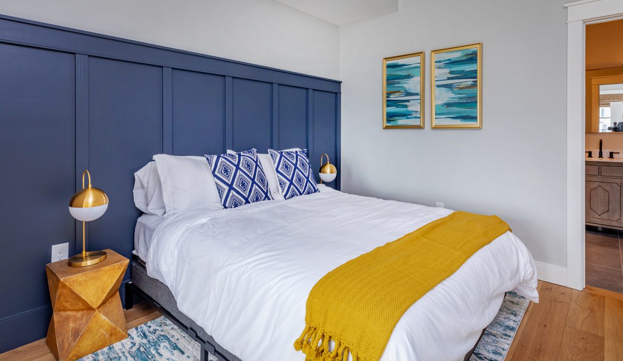 a bedroom with a blue headboard and a yellow blanket.
