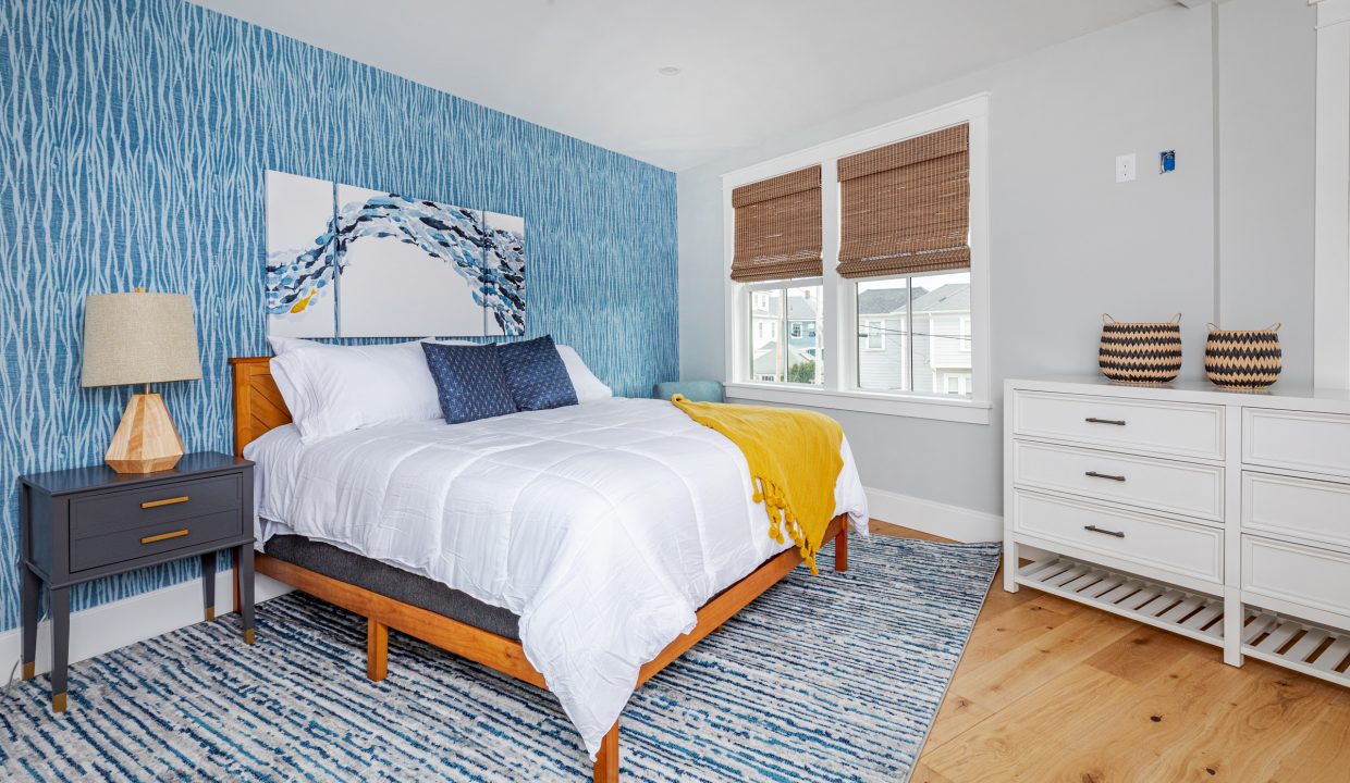 a bedroom with blue and white wallpaper and a bed.