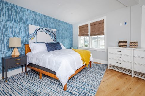 a bedroom with blue and white wallpaper and a bed.