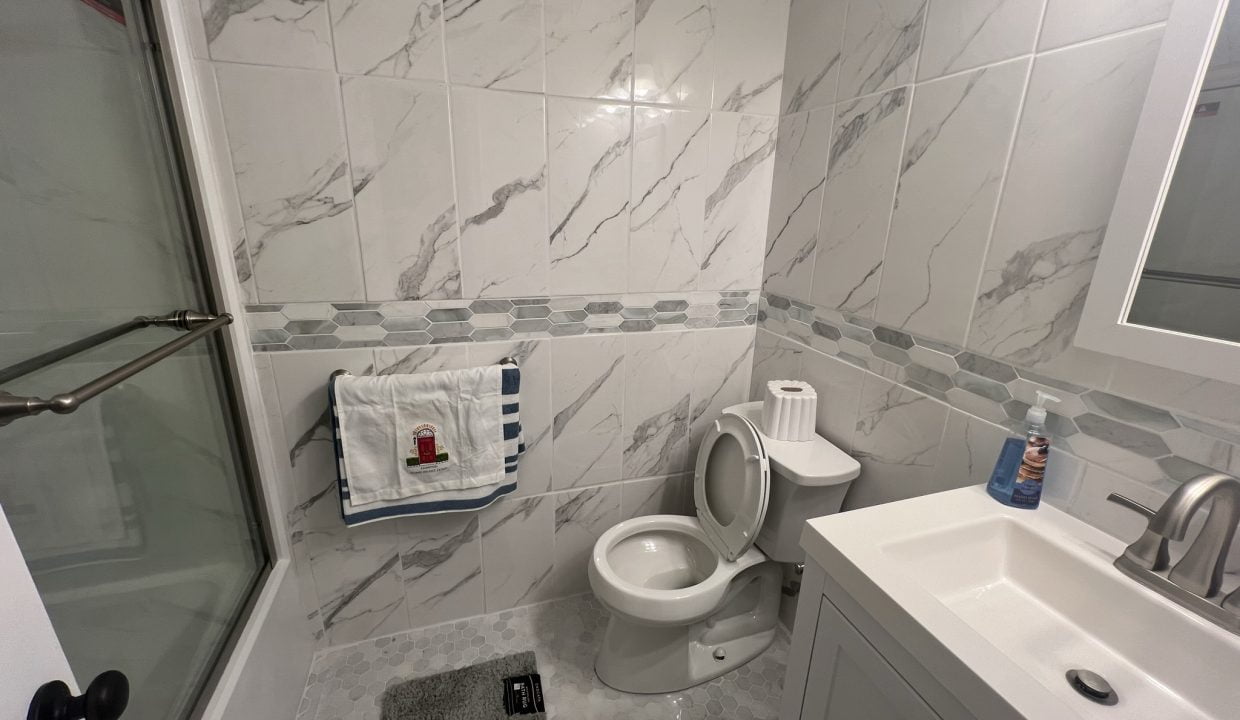 a white toilet sitting next to a white sink.