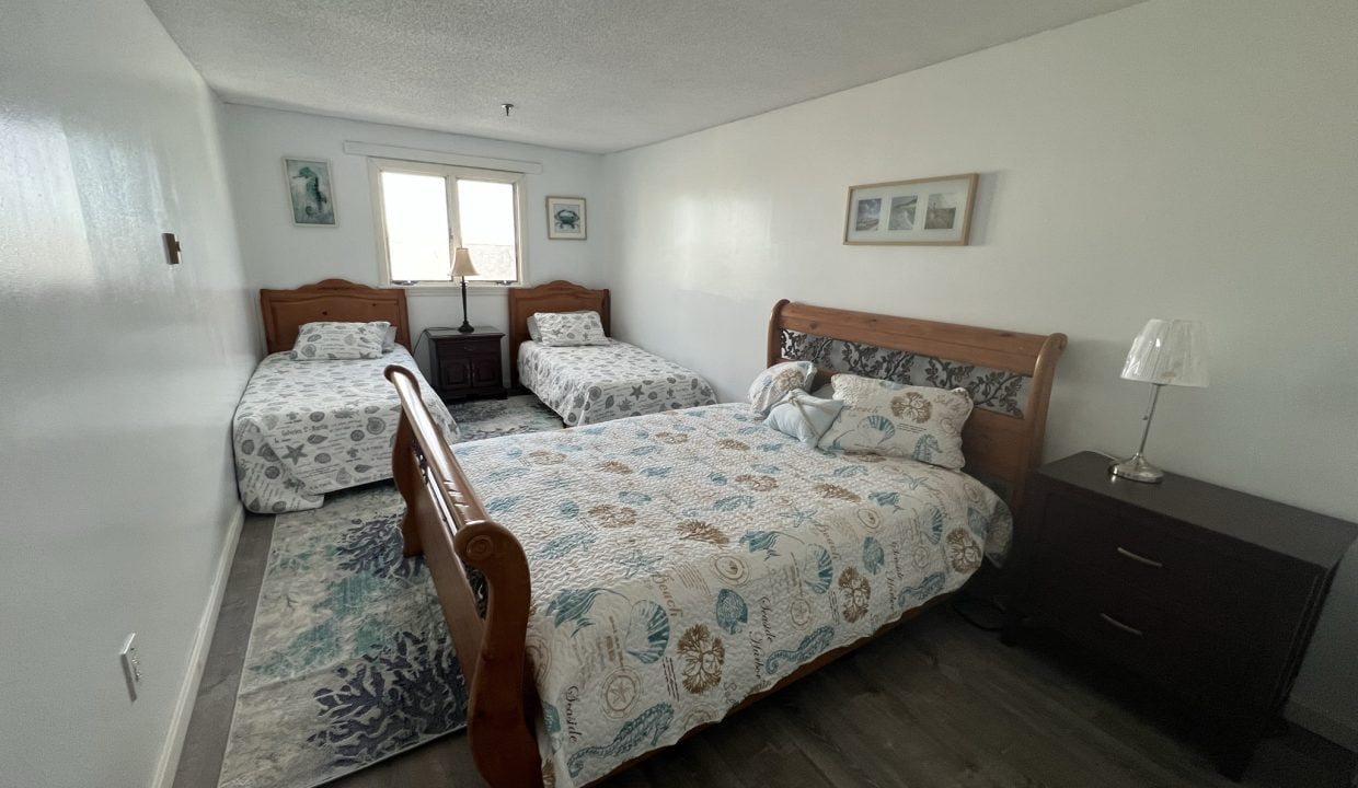 a bed room with two beds and a night stand.