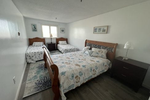 a bed room with two beds and a night stand.