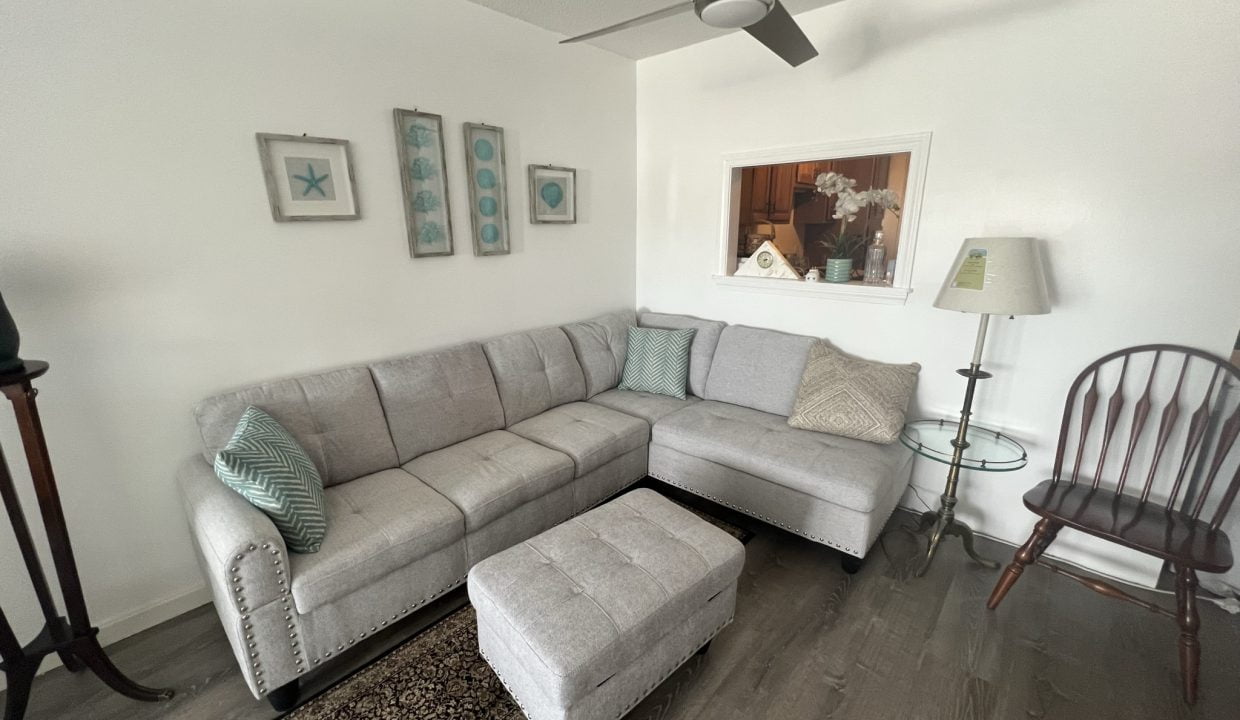 a living room with a sectional couch and a chair.