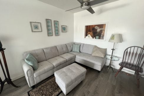 a living room with a sectional couch and a chair.