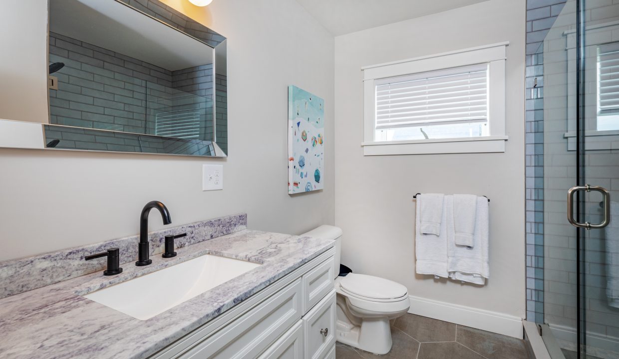 a bathroom with a sink, toilet, and shower.