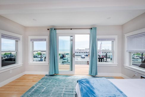 a bedroom with a large bed and two windows.