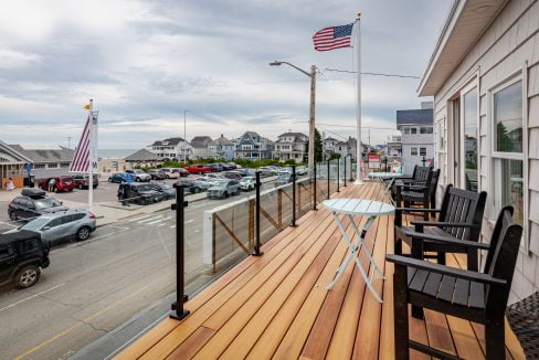 a wooden deck with chairs and a table on it.