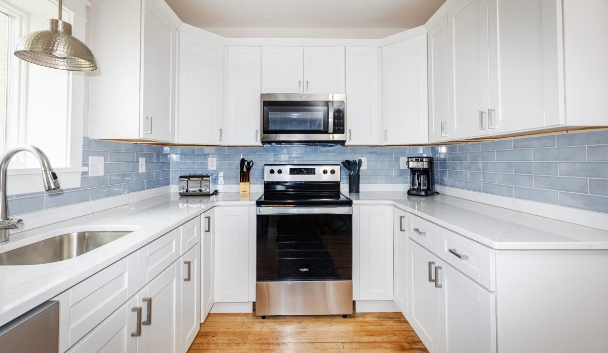 a kitchen with white cabinets and stainless steel appliances.