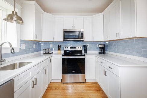 a kitchen with white cabinets and stainless steel appliances.