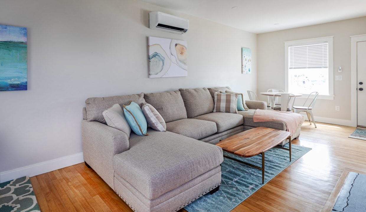 a living room filled with furniture and a wooden floor.