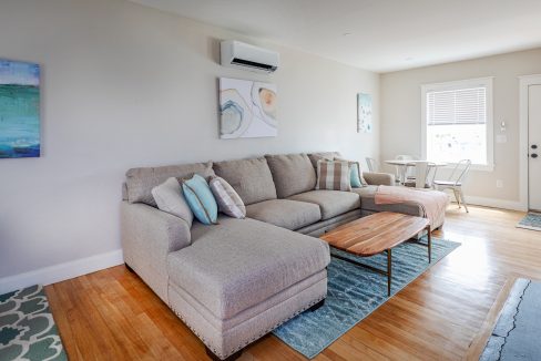 a living room filled with furniture and a wooden floor.