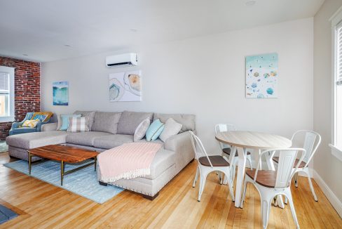 a living room filled with furniture and a wooden floor.