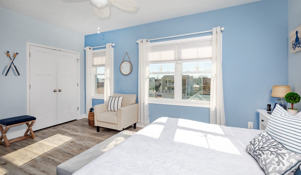 a bedroom with blue walls and a white bed.