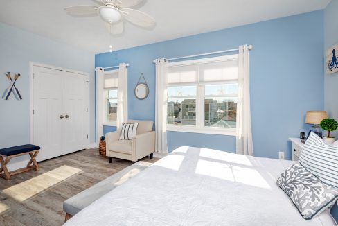 a bedroom with blue walls and a white bed.