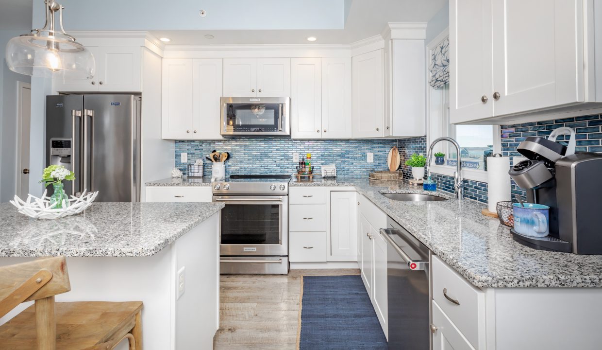 a kitchen with white cabinets and silver appliances.