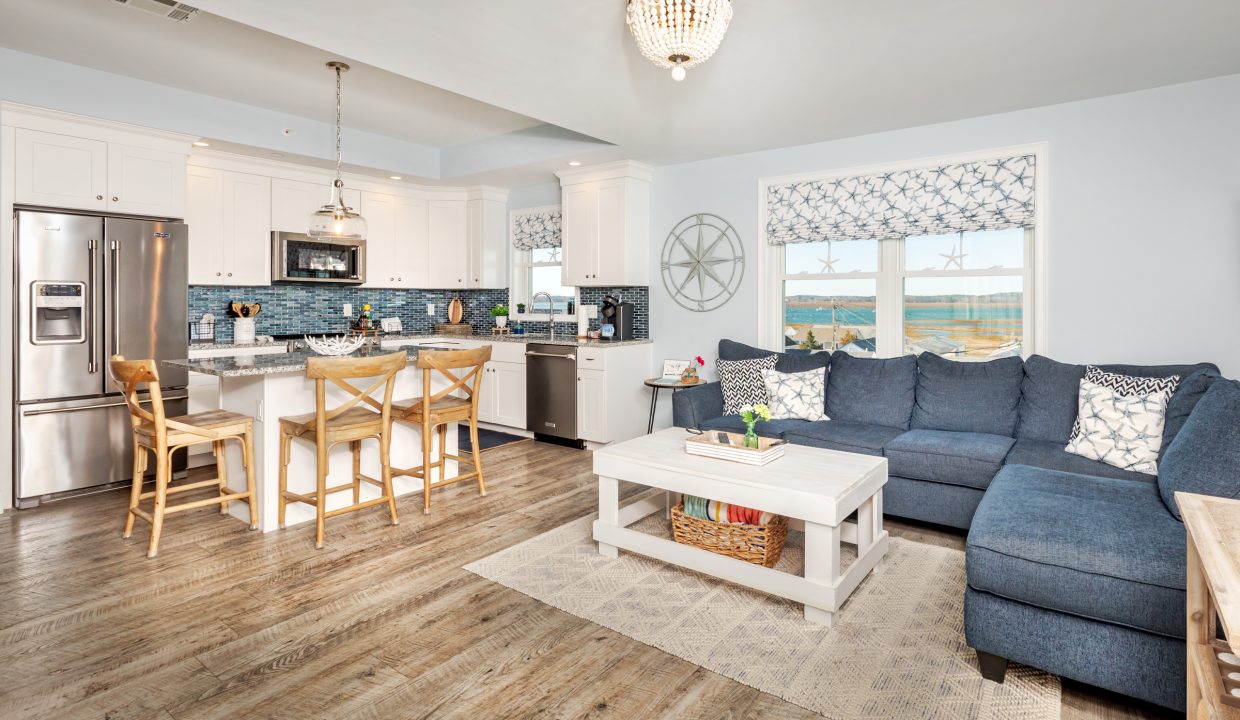 a living room filled with furniture and a kitchen.