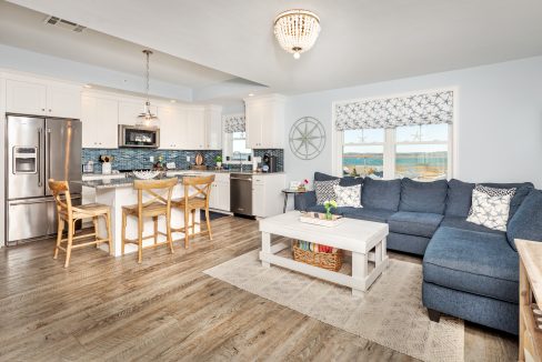 a living room filled with furniture and a kitchen.