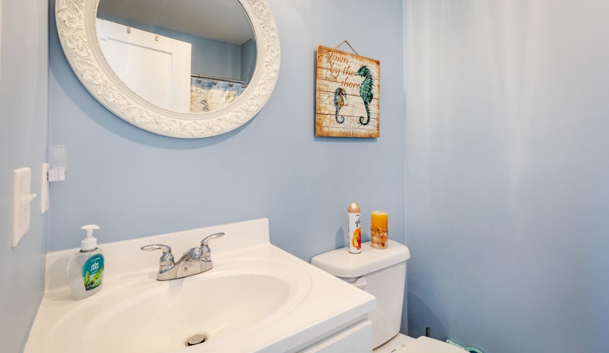 a bathroom with a sink, toilet and mirror.