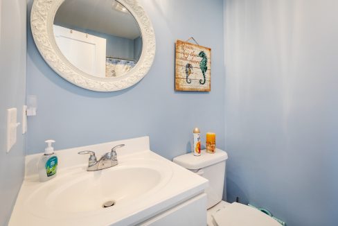 a bathroom with a sink, toilet and mirror.