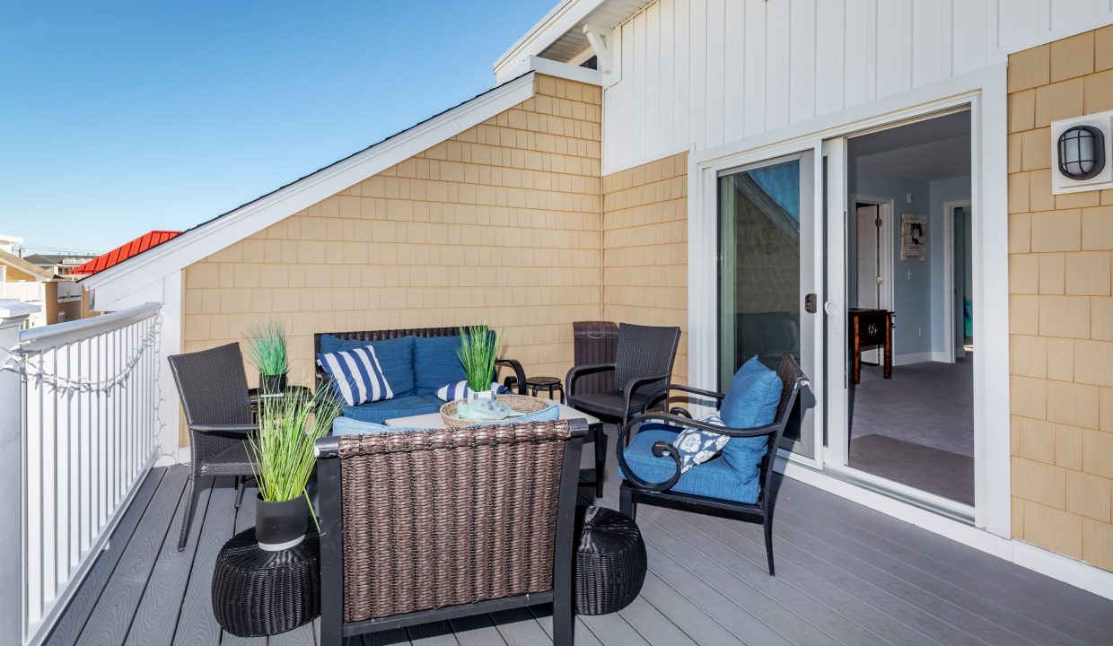 a patio with wicker furniture and blue cushions.