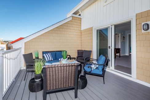 a patio with wicker furniture and blue cushions.