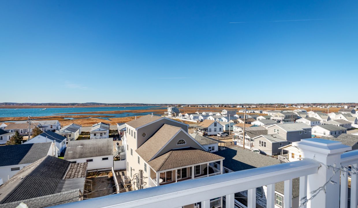 a balcony with a view of the ocean and houses.