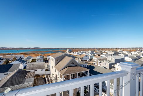 a balcony with a view of the ocean and houses.